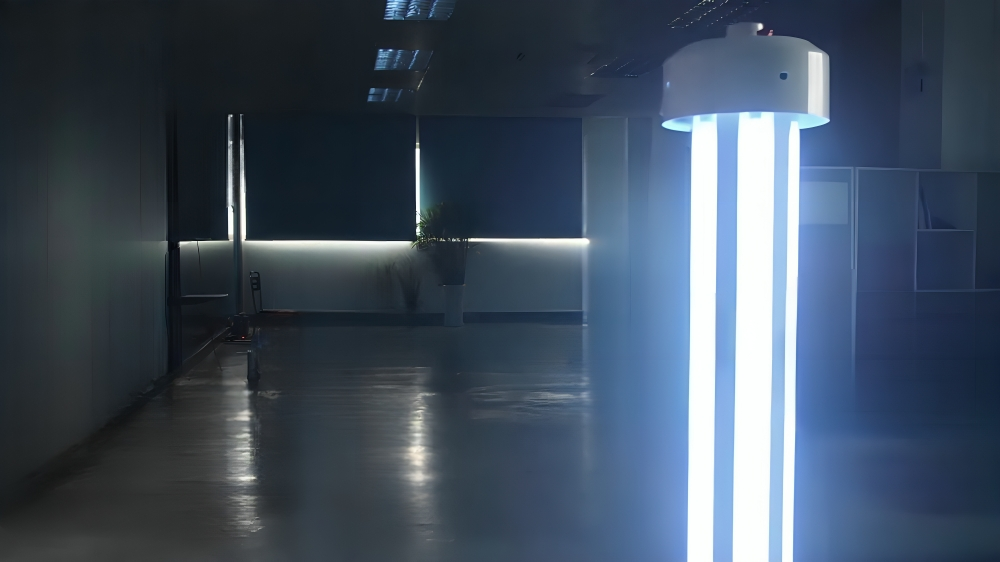 RUVi UVC disinfection robot operating in a dark hospital room with visible UV-C light irradiation