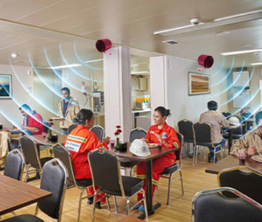 People dining in a staff canteen under ViRaTon disinfection waves.